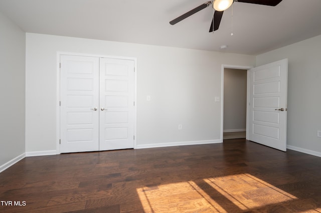 unfurnished bedroom featuring ceiling fan, dark hardwood / wood-style flooring, and a closet