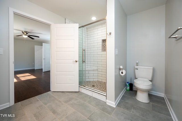bathroom with ceiling fan, toilet, an enclosed shower, and tile patterned flooring