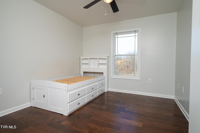 unfurnished bedroom featuring ceiling fan and dark hardwood / wood-style flooring