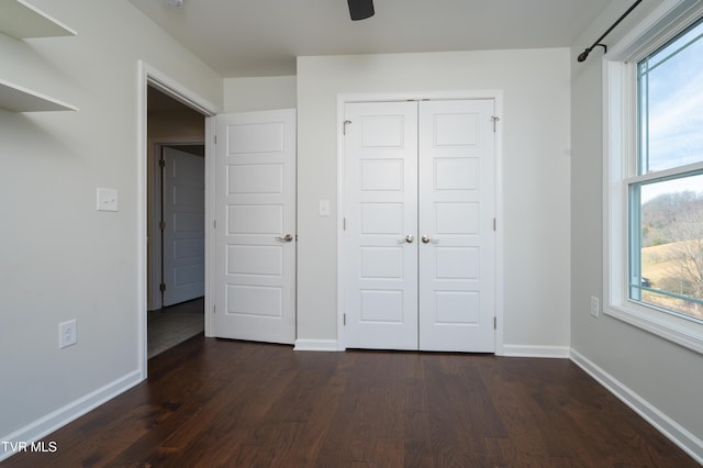 unfurnished bedroom with a closet and dark hardwood / wood-style floors