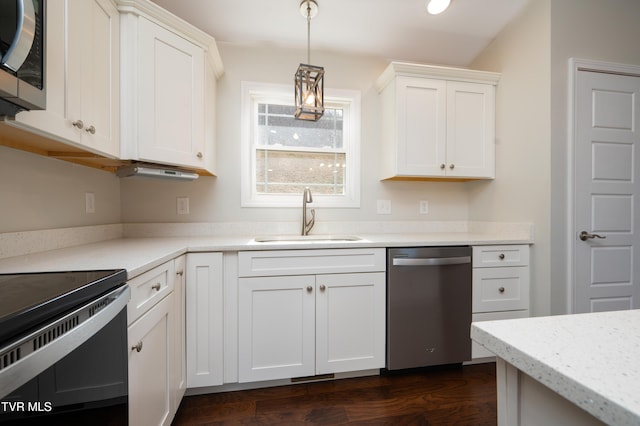 kitchen featuring white cabinetry, appliances with stainless steel finishes, sink, and decorative light fixtures