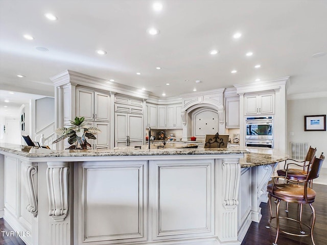 400 Bancroft Chapel Rd, Kingsport, TN 37660 - kitchen featuring crown molding, light stone counters, dark wood-type flooring, a breakfast bar area, and a peninsula