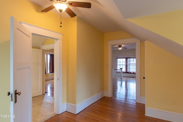 corridor with lofted ceiling and light hardwood / wood-style flooring