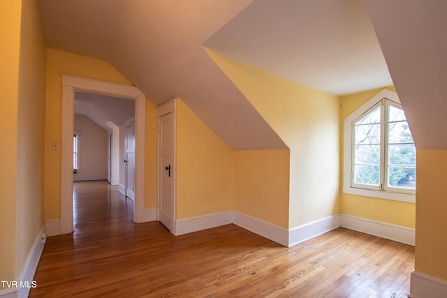 bonus room featuring vaulted ceiling and light wood-type flooring