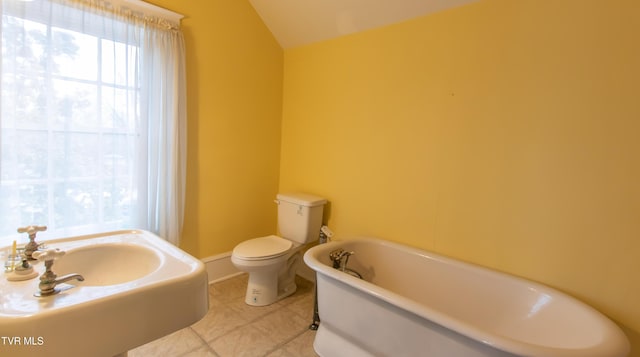 bathroom with a washtub, tile patterned floors, and toilet