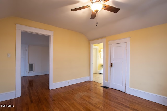 empty room with lofted ceiling, hardwood / wood-style floors, and ceiling fan