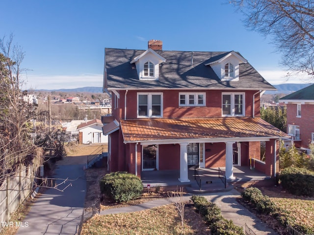 view of front of property featuring a hot tub, a mountain view, and covered porch