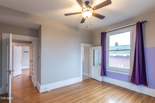 empty room with ceiling fan and light wood-type flooring