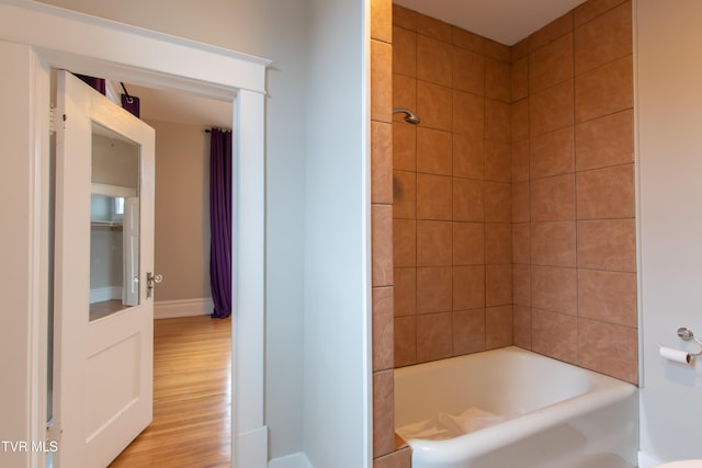 bathroom featuring hardwood / wood-style floors and tiled shower / bath