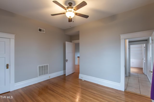 unfurnished bedroom with ceiling fan and light hardwood / wood-style floors