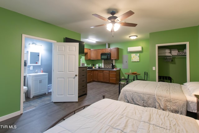 bedroom with sink, dark hardwood / wood-style floors, connected bathroom, a wall mounted air conditioner, and a closet