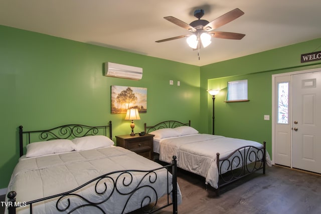 bedroom featuring a wall mounted air conditioner, wood-type flooring, and ceiling fan