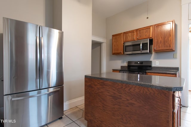 kitchen with light tile patterned flooring, a center island, and appliances with stainless steel finishes