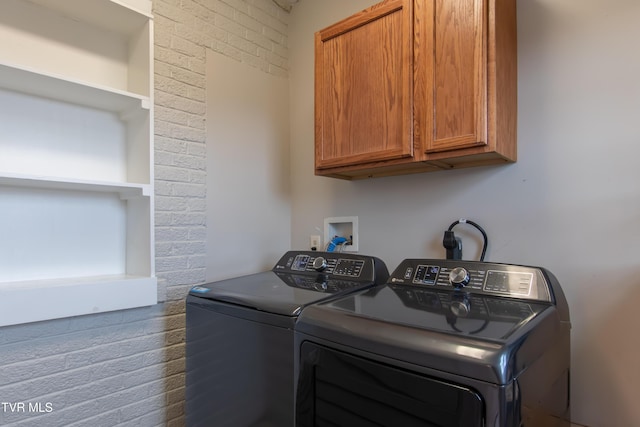 clothes washing area with cabinets and separate washer and dryer