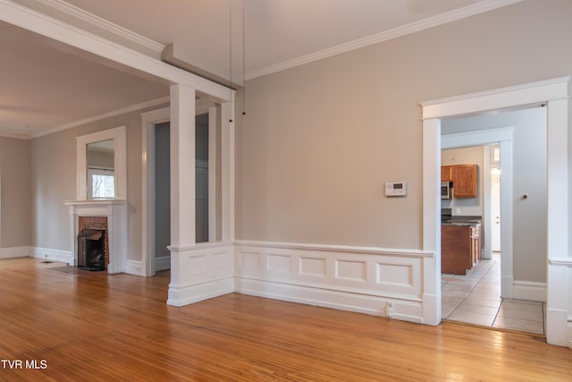 unfurnished living room featuring crown molding and light hardwood / wood-style flooring