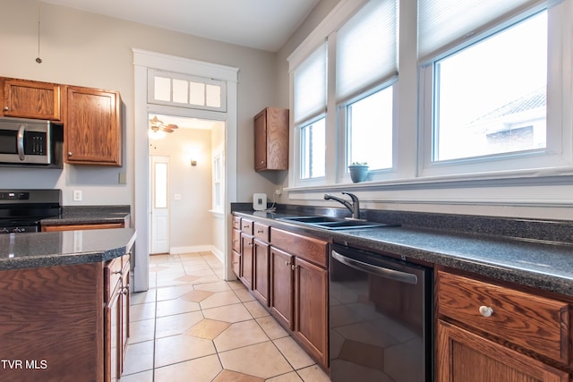 kitchen with stainless steel appliances, light tile patterned flooring, and sink