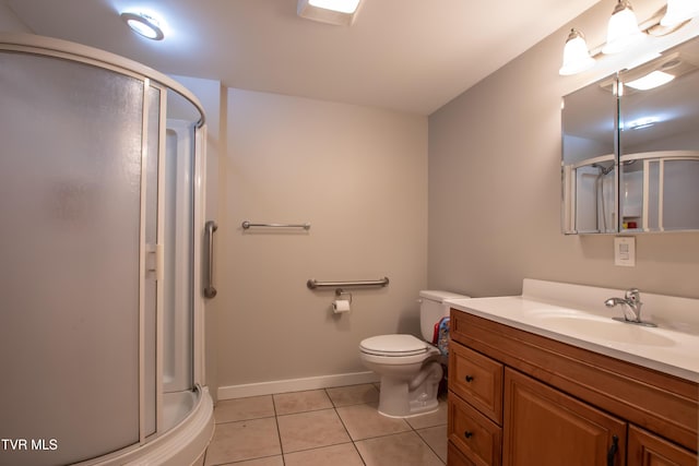 bathroom featuring tile patterned flooring, vanity, a shower with door, and toilet