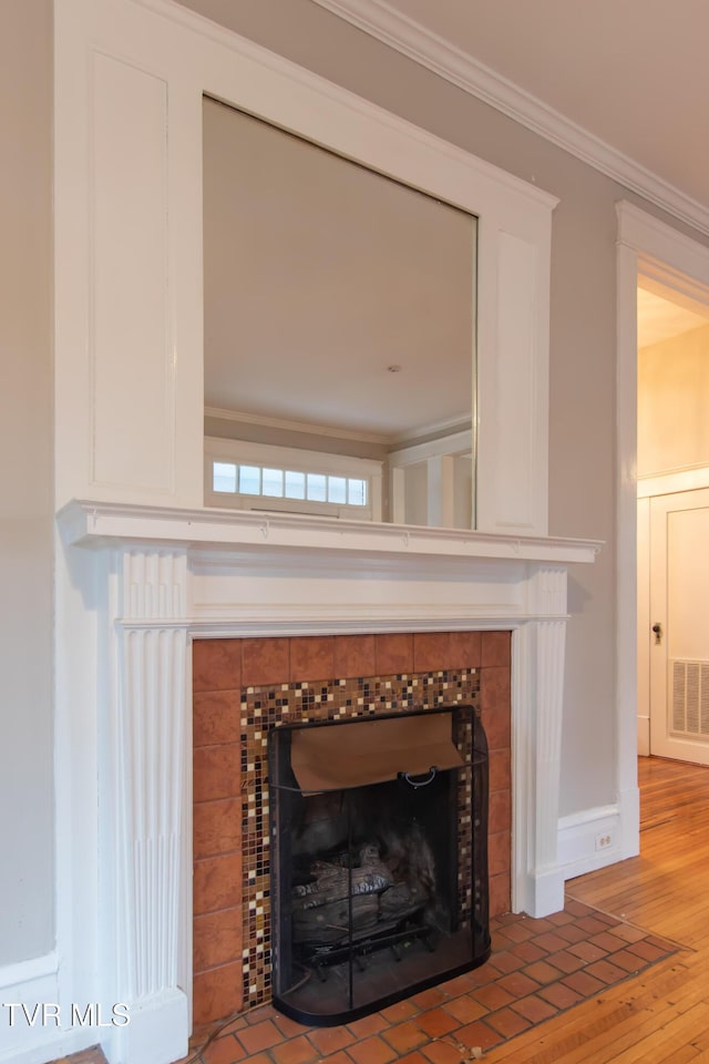 details featuring hardwood / wood-style flooring, a fireplace, and ornamental molding