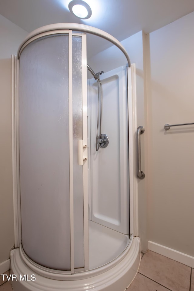 bathroom featuring a shower with shower door and tile patterned floors