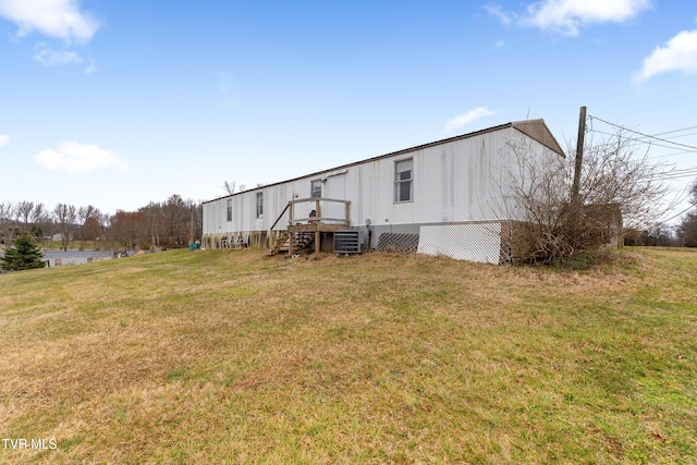 back of property featuring central AC and a yard