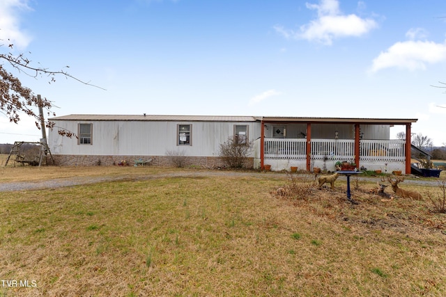 manufactured / mobile home featuring covered porch and a front lawn