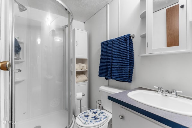 full bathroom with a textured ceiling, toilet, a shower stall, and vanity