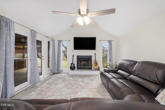 living room featuring a wealth of natural light, ceiling fan, and vaulted ceiling