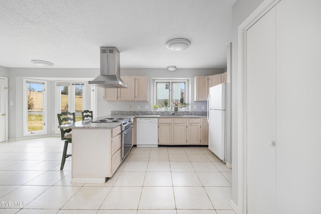 kitchen with sink, white appliances, a kitchen breakfast bar, island range hood, and light tile patterned flooring