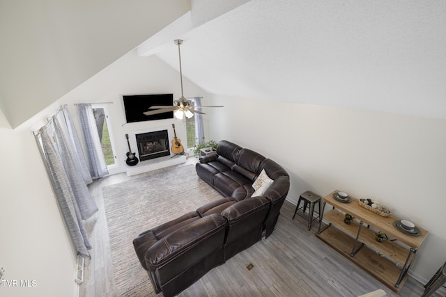 living room with lofted ceiling with beams, ceiling fan, and light wood-type flooring