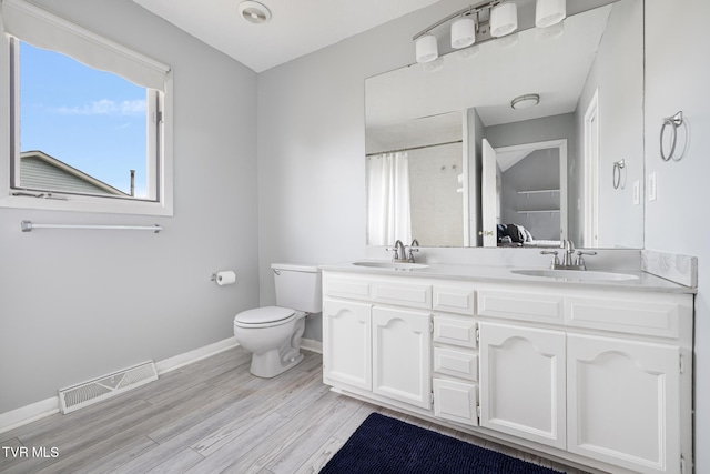 bathroom with hardwood / wood-style flooring, vanity, a shower with curtain, and toilet