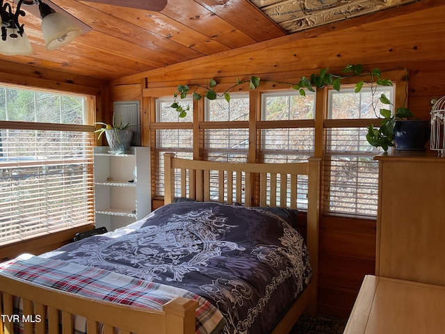 bedroom with lofted ceiling, wooden ceiling, and wooden walls