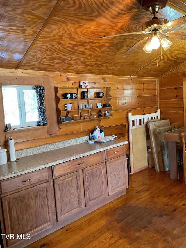 kitchen with lofted ceiling, wood walls, wooden ceiling, and wood finished floors