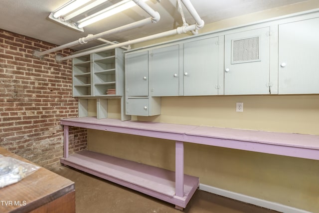 basement featuring brick wall