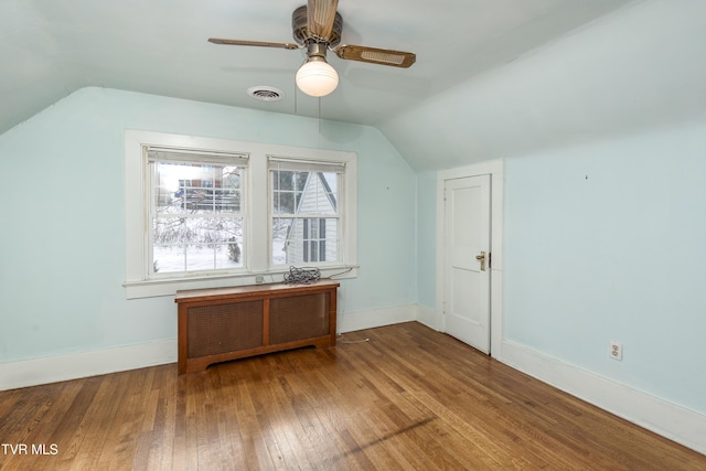 bonus room featuring wood-type flooring, vaulted ceiling, radiator heating unit, and ceiling fan