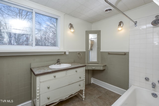 bathroom featuring crown molding, bathing tub / shower combination, tile walls, tile patterned flooring, and vanity