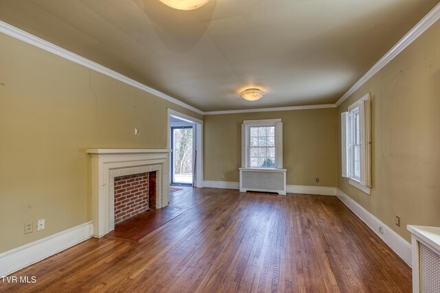 unfurnished living room featuring a tiled fireplace, radiator, dark hardwood / wood-style flooring, and ornamental molding