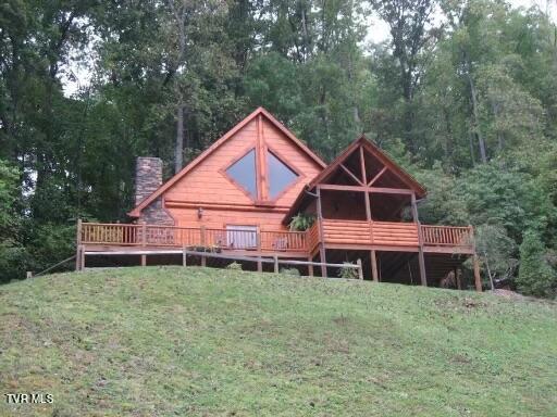 back of house featuring a yard and a deck