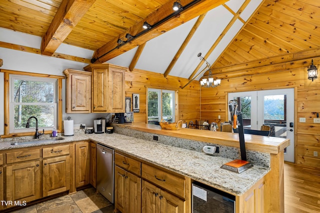 kitchen with wine cooler, sink, stainless steel dishwasher, wooden walls, and kitchen peninsula