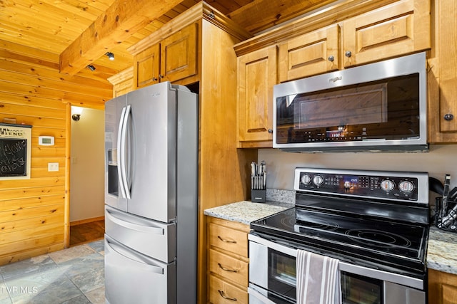 kitchen with appliances with stainless steel finishes, wood walls, wood ceiling, light stone counters, and beam ceiling