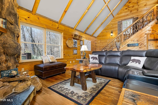 living room featuring wood-type flooring, a healthy amount of sunlight, and wood walls