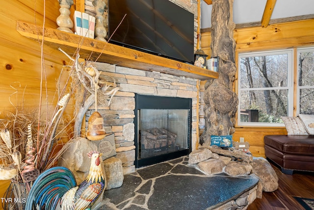 living room featuring hardwood / wood-style flooring, plenty of natural light, a fireplace, and beam ceiling