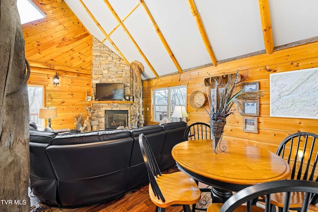 dining room featuring wood-type flooring, high vaulted ceiling, a fireplace, and wood walls