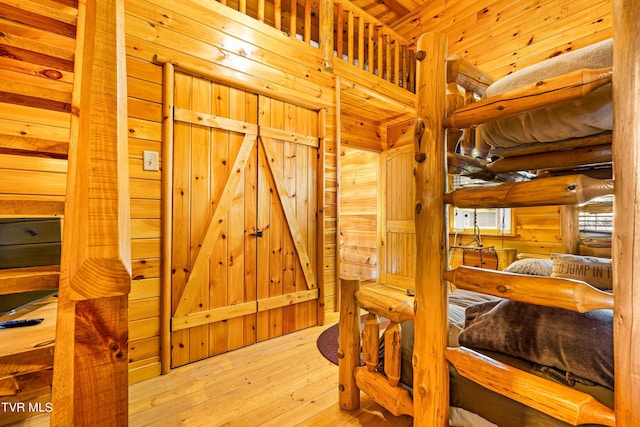 bedroom featuring rustic walls and light hardwood / wood-style flooring