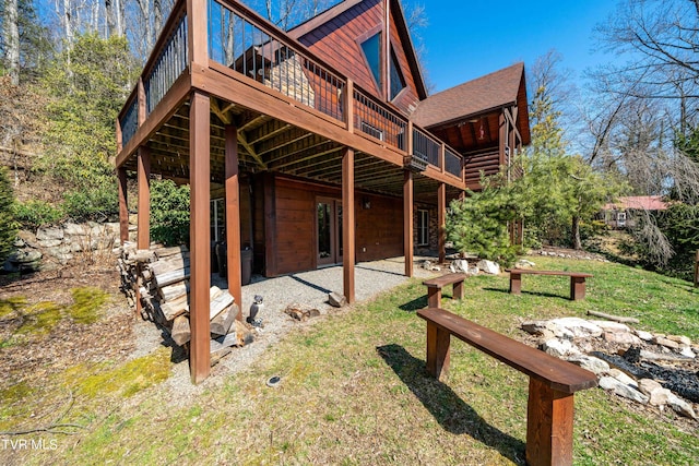 view of side of home with a wooden deck and a yard