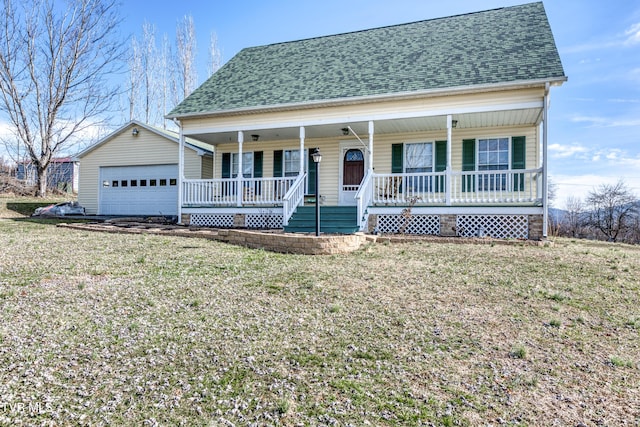 view of front of house with an outbuilding, a garage, covered porch, and a front yard