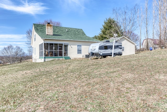 rear view of house with a sunroom and a yard