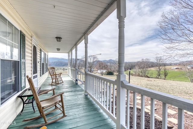 wooden deck with a porch and a mountain view