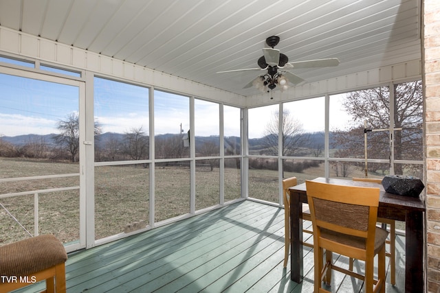 unfurnished sunroom with ceiling fan