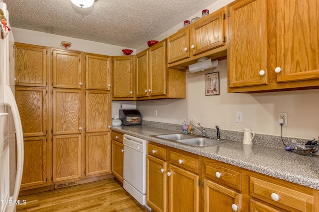 kitchen featuring dishwasher, sink, a textured ceiling, and light hardwood / wood-style flooring