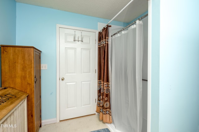 bathroom featuring a textured ceiling and a shower with shower curtain